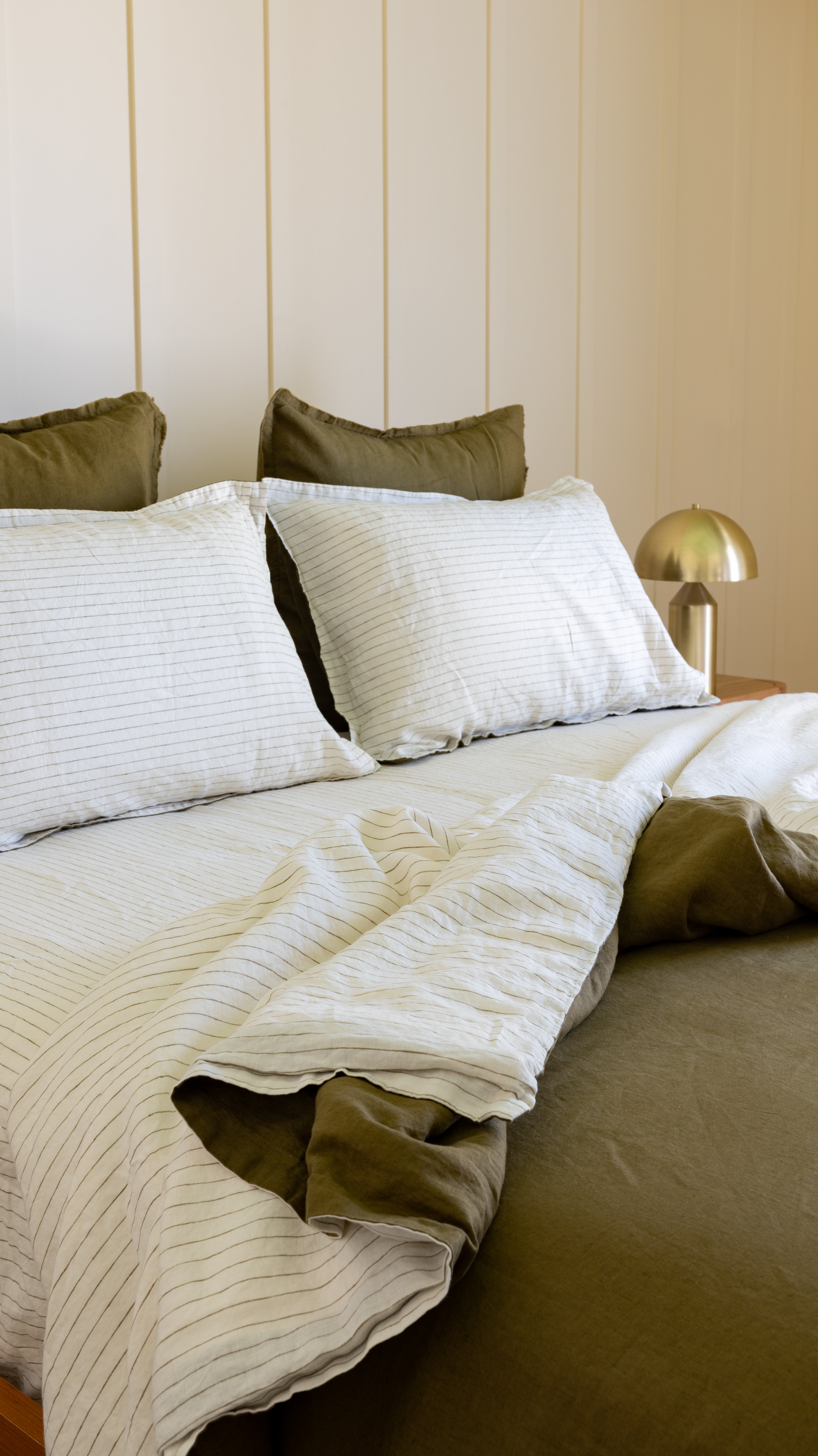 Duvet cover set with white cover and olive pillows, reversible side visible