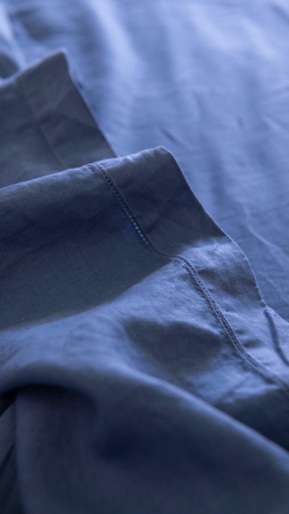 Denim blue linen fabric flat sheet corner with neat stitching