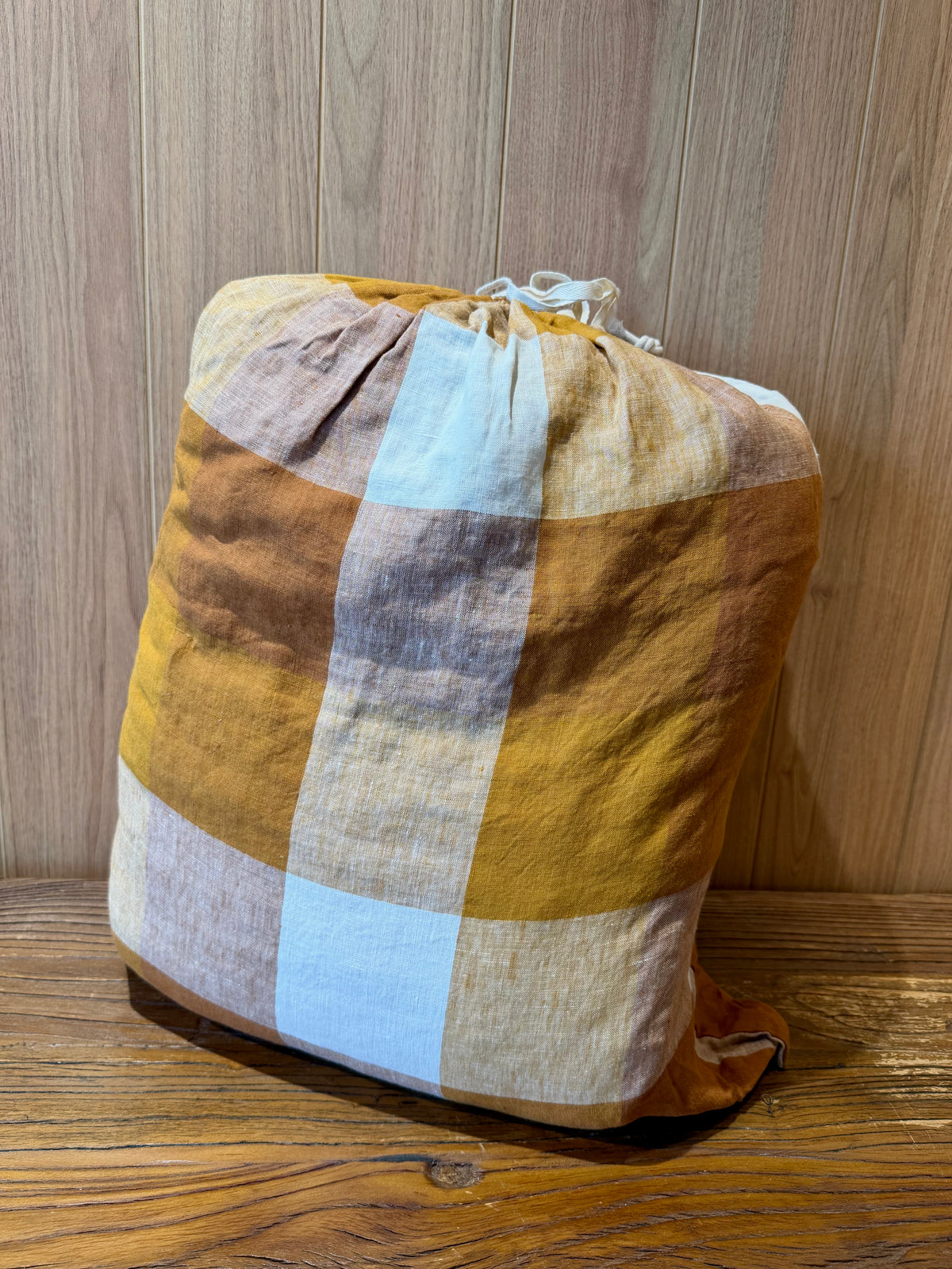 Flax linen blanket with large check pattern in terracotta and pale blue, folded