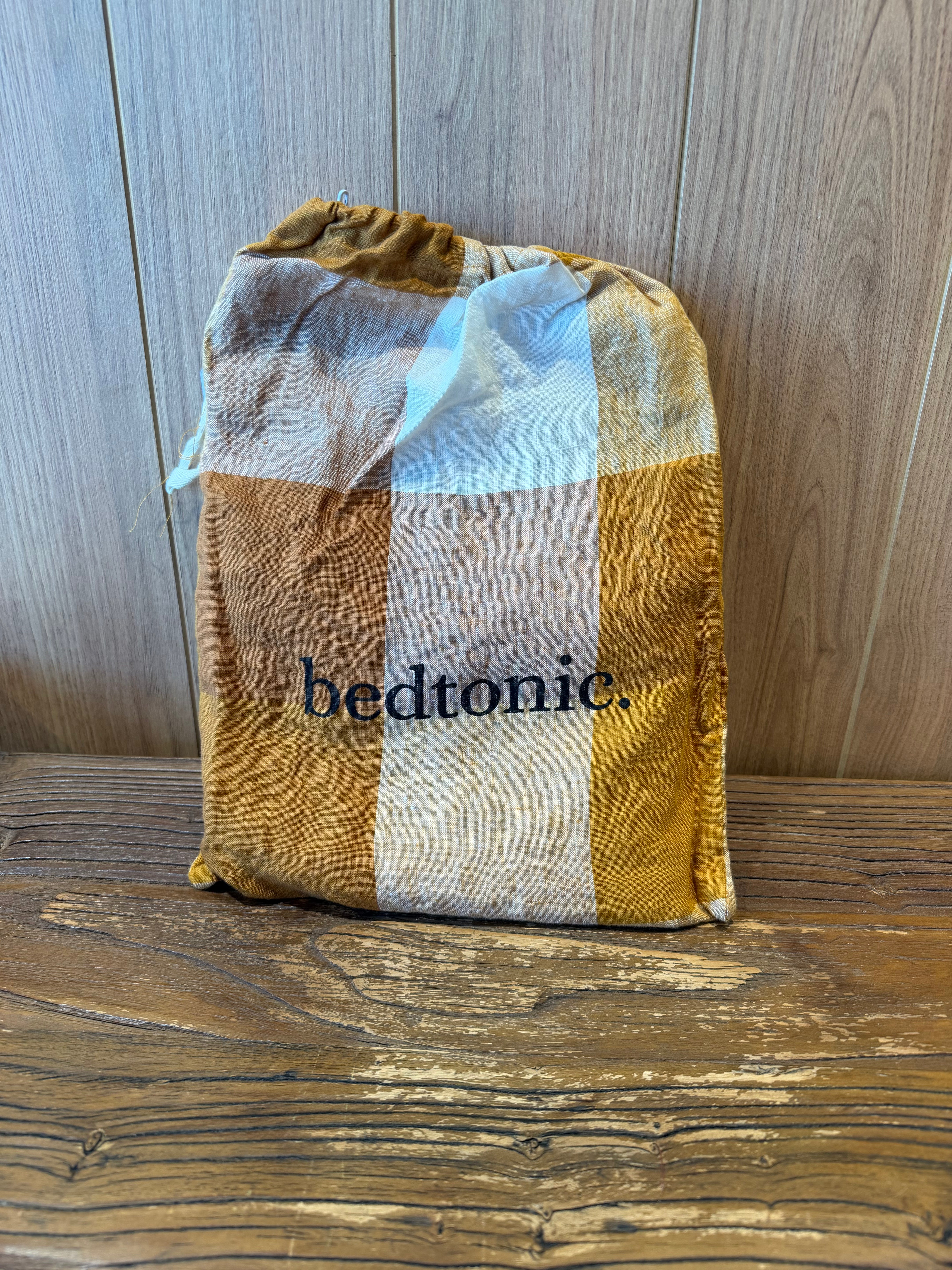 Linen pillowcase pair with terracotta check pattern and hand-frayed edges