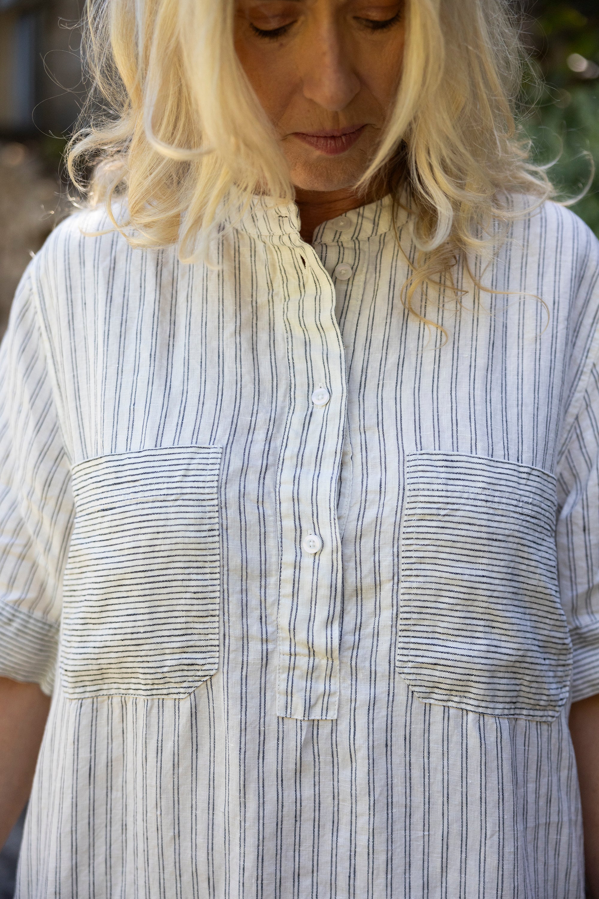 Woman wearing a striped shirt with a focus on the chest area.