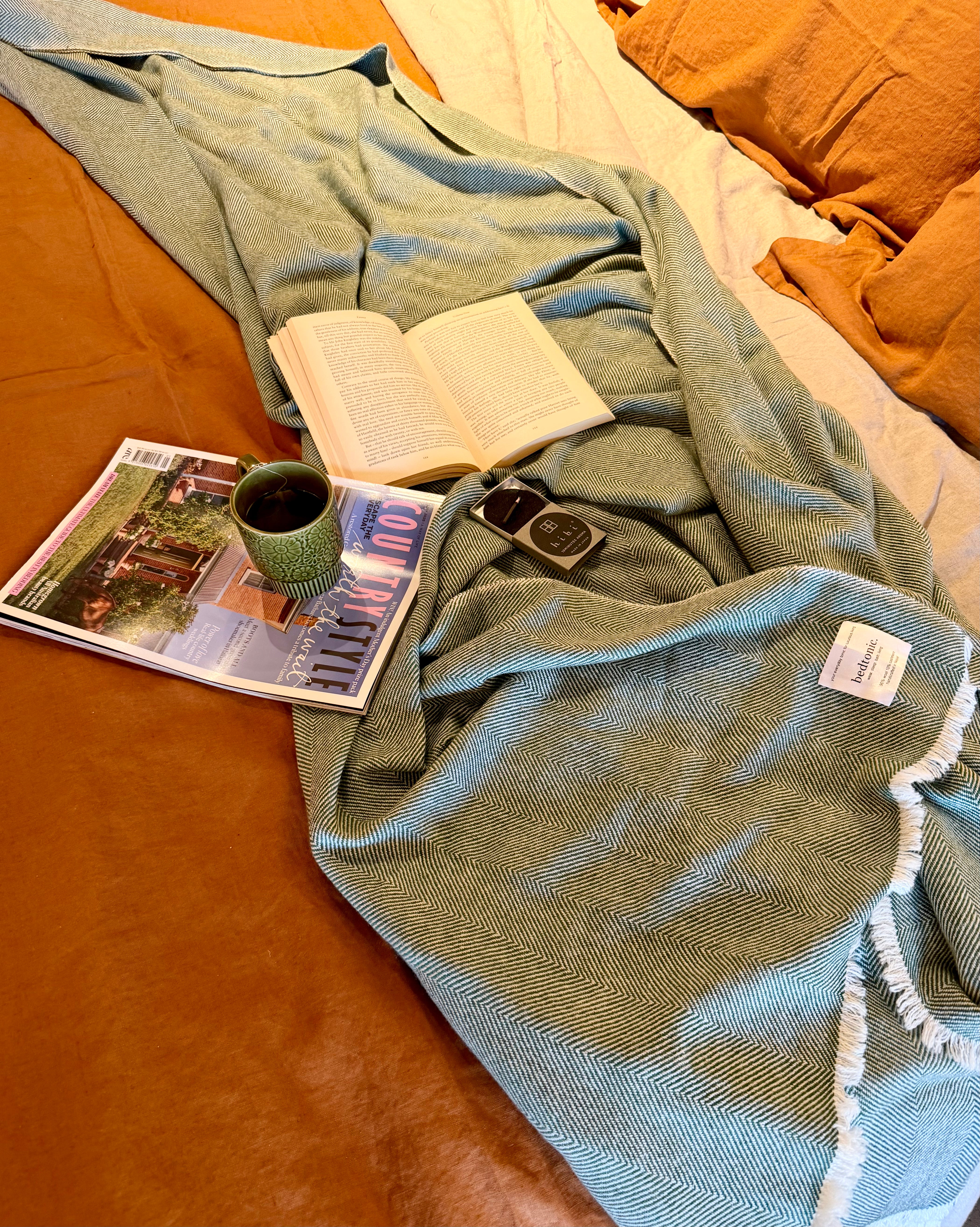 Moss green wool-cashmere throw blanket with chevron pattern and white fringed trim