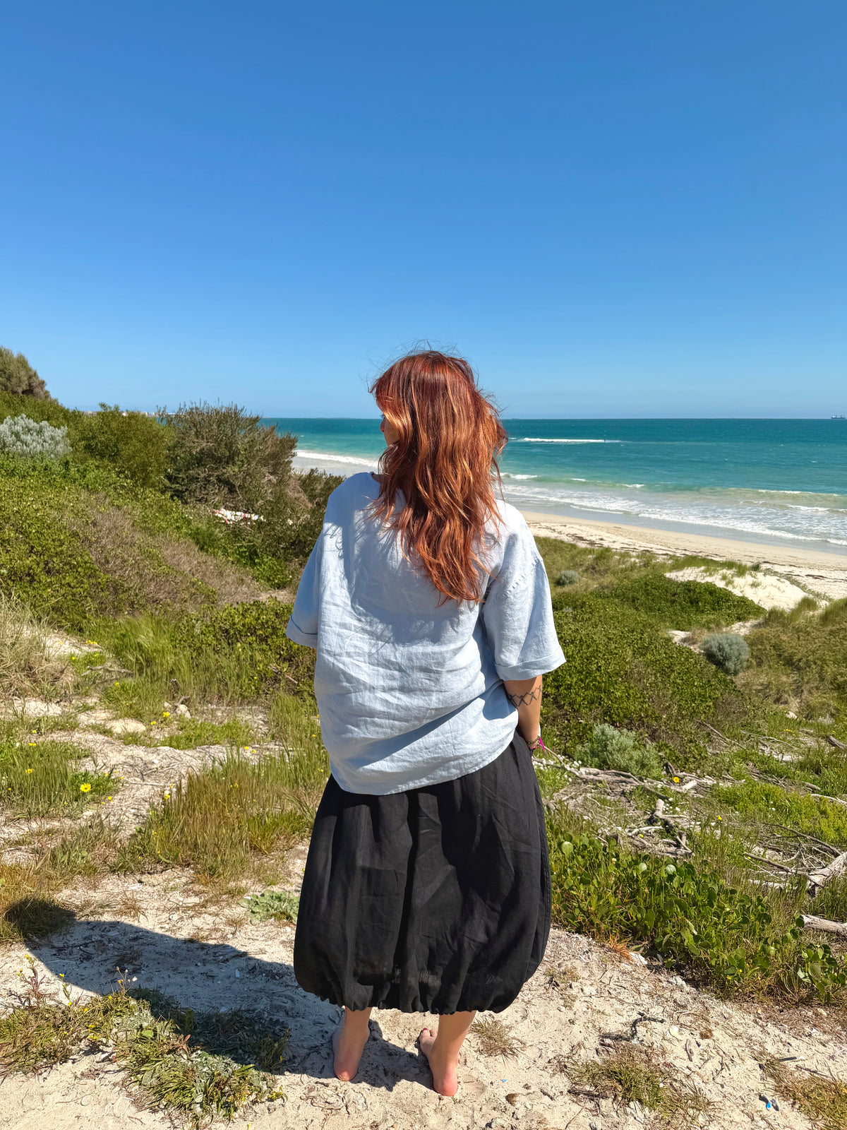 Back view of ink black tulip-style forage skirt, gathered midi with ruched tulip shape