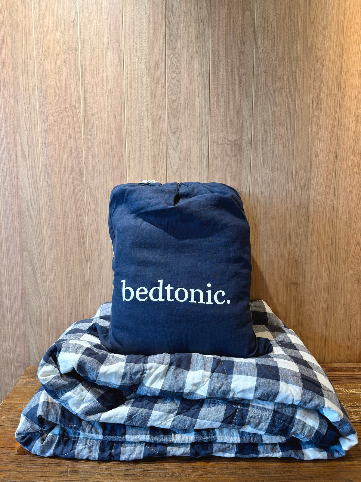 Folded indigo flax linen blanket with buffalo check pattern and ruffled trim