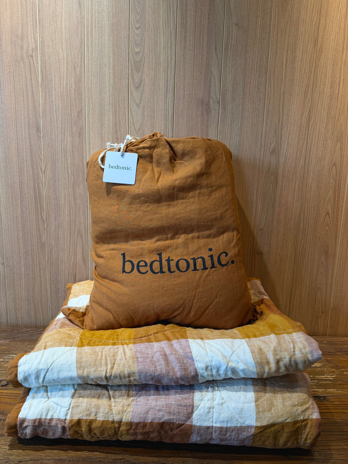Flax linen blanket in terracotta-brown with large pale blue checks, folded