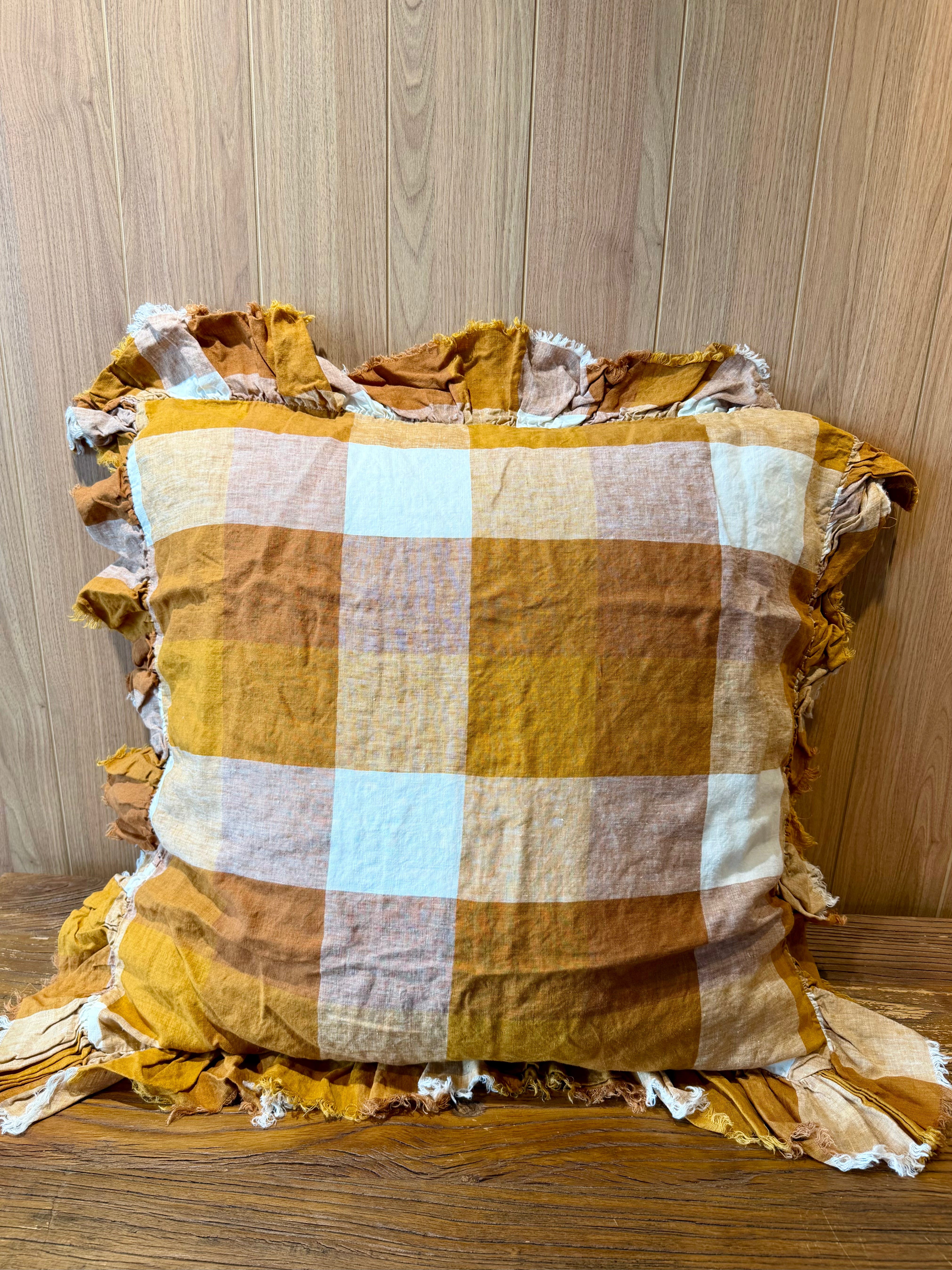 Ruffled linen pillowcase with frilled edge and warm terracotta check pattern