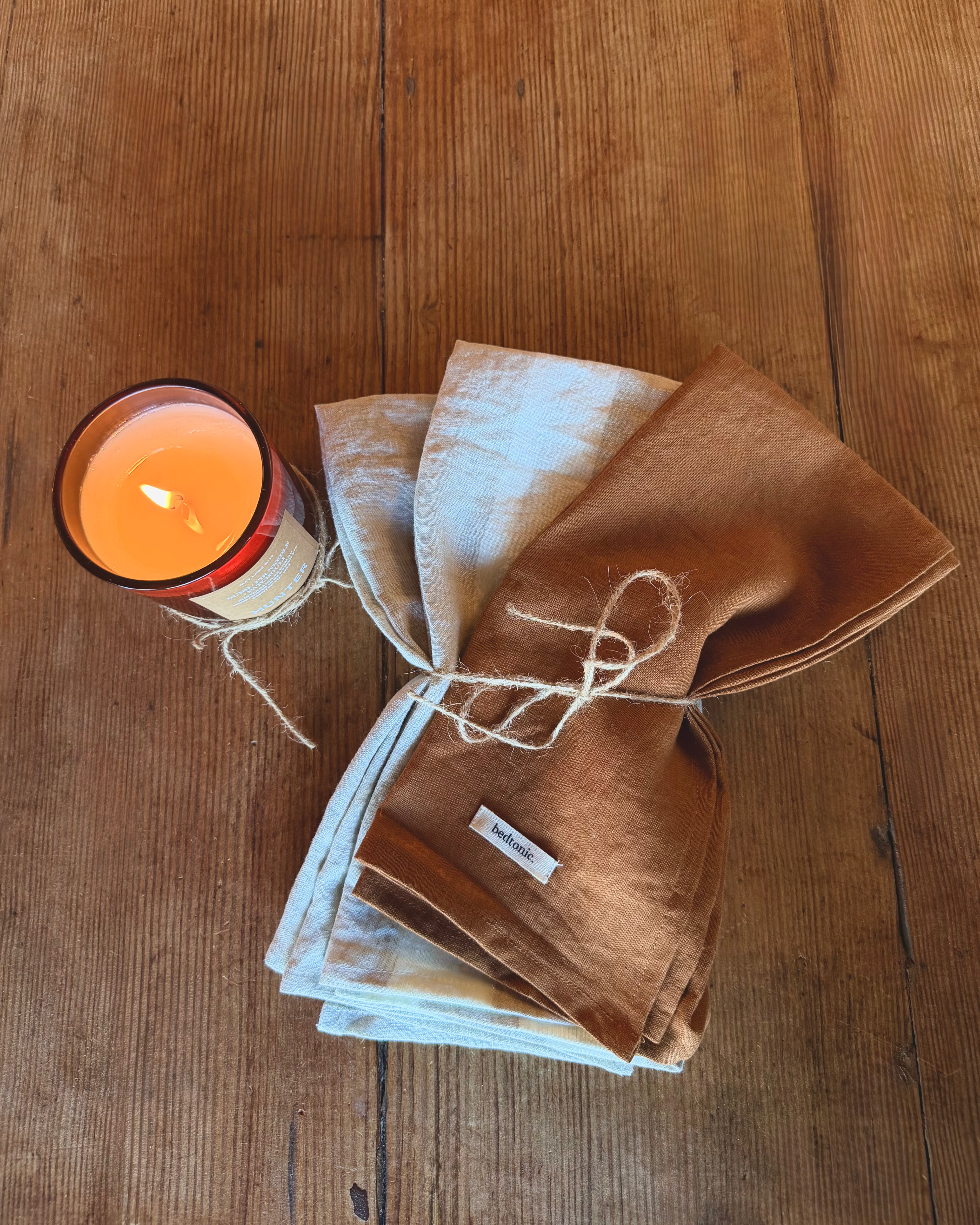 Tea towel set, folded linen towels in warm brown with light blue striped accents
