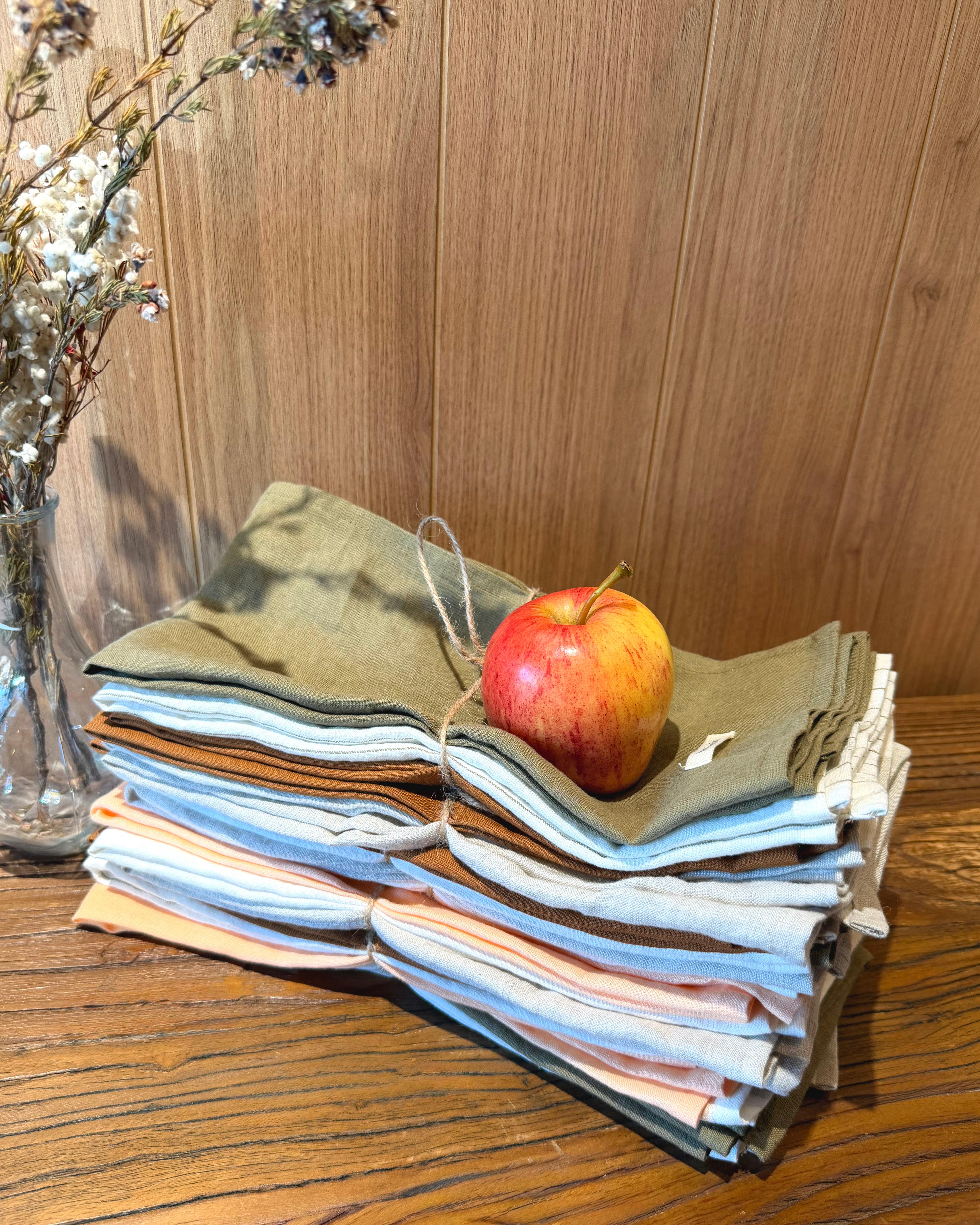Linen tea towel set stacked in olive green and striped light blue with woven tag