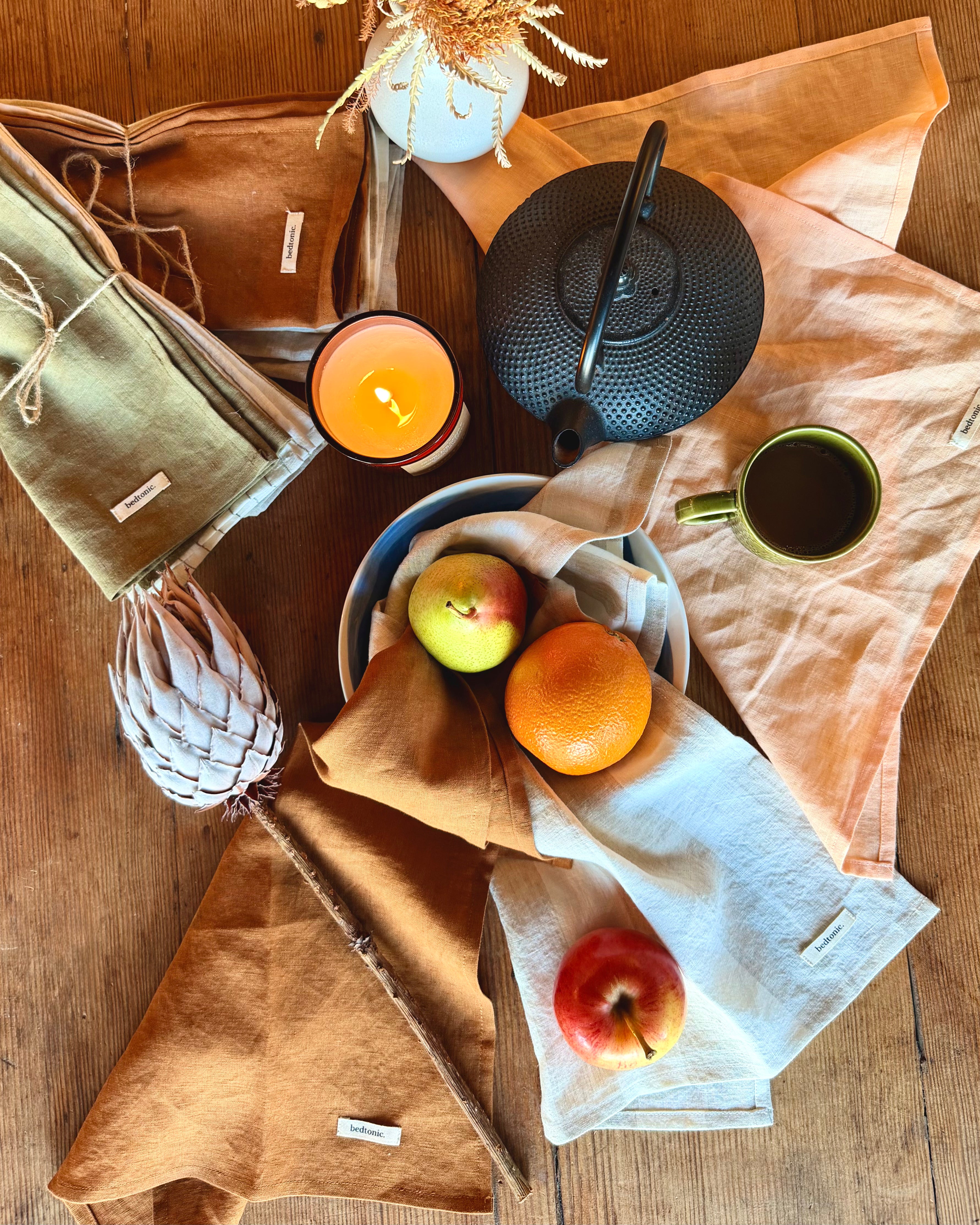 Linen tea towel set assorted colors: tan, peach, and pale blue with woven labels